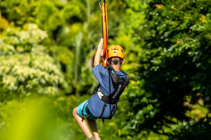 kid ziplining behind